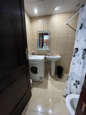 a bathroom with a washing machine and a sink at florenza khamsin studio in hurghada pool view in Hurghada