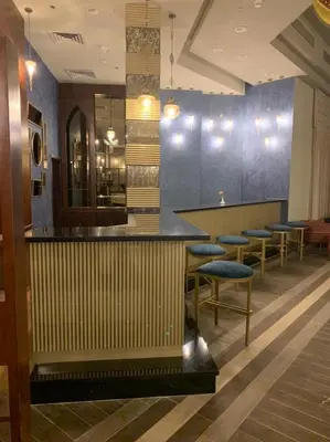 a bar in a restaurant with blue walls and stools at Lazuli Hotel, Marsa Alam in Quseir