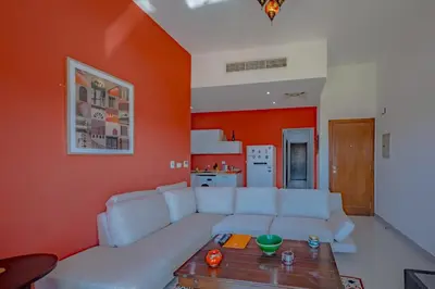 a living room with a white couch and an orange wall at VESTA - El Gouna Residence in Hurghada