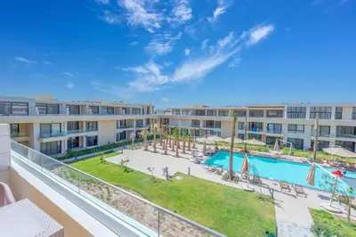 an apartment balcony with a pool and a resort at VESTA - El Gouna Residence in Hurghada