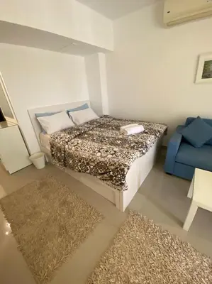 a small bedroom with a bed and a blue couch at G cribs B1F2 in Hurghada