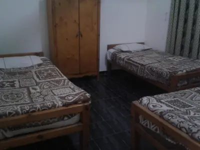 a room with two twin beds and a cabinet at Sea Waves Hostel not for Egyptian in Hurghada