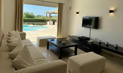 a living room with a white couch and a tv at Villa with 5 bedrooms & 4 bathrooms - private heated pool in Hurghada