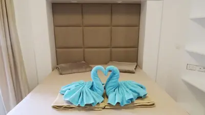 two towels in the shape of swans sitting on a table at Aqua Palms Studio A210 in Hurghada