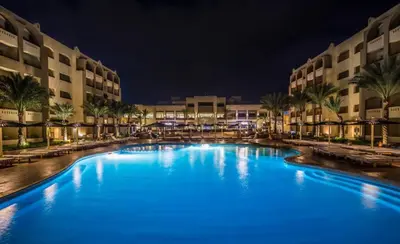 a large pool with blue water in front of buildings at El Karma Beach Resort & Aqua Park - Hurghada in Hurghada