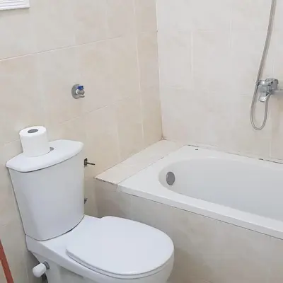 a white bathroom with a toilet and a bath tub at Sweet Home 5 Open 24 Hour in Hurghada