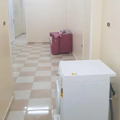 a kitchen with a refrigerator and a pink suitcase at Sweet Home 5 Open 24 Hour in Hurghada