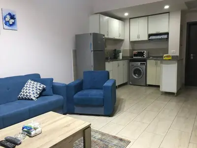a living room with a blue couch and a kitchen at AlDau Hights one Bedroom Elegante Apartment 10201 in Hurghada