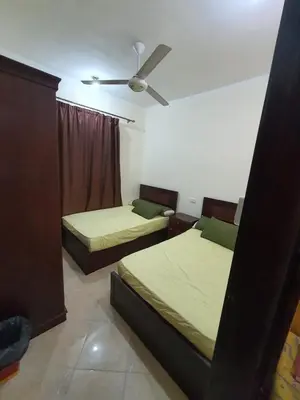 a bedroom with two beds and a ceiling fan at Abeer Suites in Hurghada