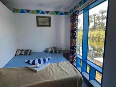 a bedroom with a bed and a large window at Luxor Old Nile Hotel in Luxor