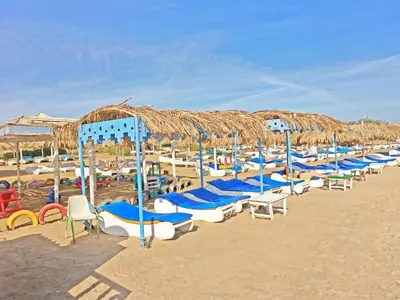 a bunch of chairs and umbrellas on a beach at The Touristic Promenade Apartment in Hurghada