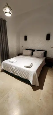 a bedroom with a large white bed with two towels on it at Nayah Stays, Lagoons beach, Paradise 3 ensuite with private pool in El Gouna