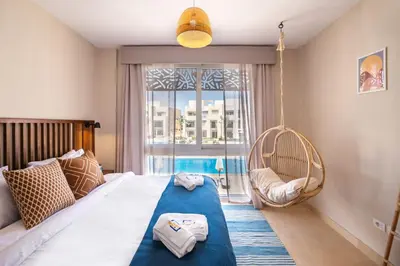 a bedroom with a bed with a swing and a window at Epic & Exquisite 2 BR w Beach & Pool Mangroovy in Hurghada