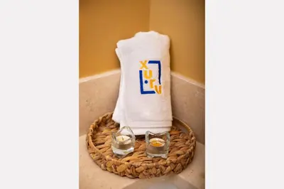 a towel and two glasses of water in a basket at Epic & Exquisite 2 BR w Beach & Pool Mangroovy in Hurghada