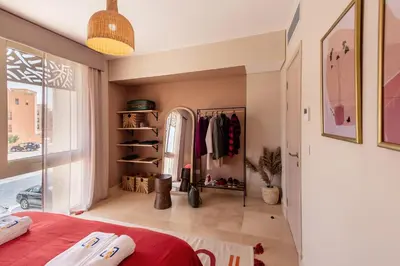 a bedroom with a red bed and a closet at Epic & Exquisite 2 BR w Beach & Pool Mangroovy in Hurghada