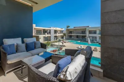 a living room with wicker furniture and a swimming pool at Cozy Studio in G-Cribs with pool - Golden Apartments El Gouna in Hurghada