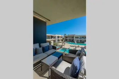 a patio with a couch and chairs and a pool at Cozy Studio in G-Cribs with pool - Golden Apartments El Gouna in Hurghada