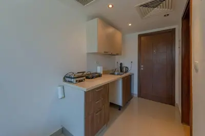 a kitchen with a counter and a wooden door at Cozy Studio in G-Cribs with pool - Golden Apartments El Gouna in Hurghada