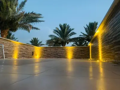 a row of lights on a wall with palm trees at Chalet stella makadi family only in Hurghada
