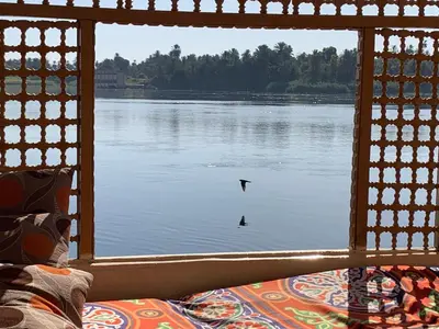 a view of a lake from a window with a bird in the water at JJ Jamaica Felucca in Aswan