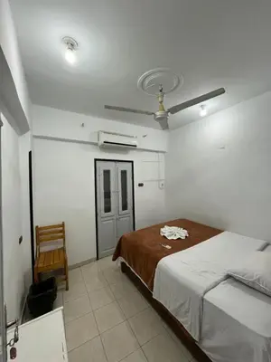a bedroom with a bed and a chair in it at SWEET HOSTEL LUXOR in Luxor