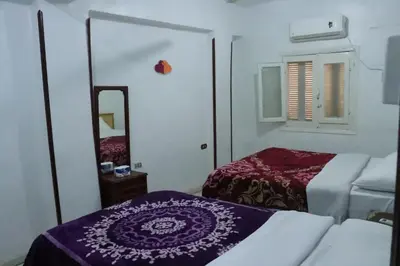 a small room with two beds and a mirror at SWEET HOSTEL LUXOR in Luxor
