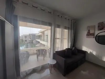 a living room with a couch and a large window at Renovated Lovely Cozy Studio in G Cribs, Elgouna in Hurghada
