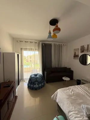 a bedroom with a bed and a couch and a window at Renovated Lovely Cozy Studio in G Cribs, Elgouna in Hurghada