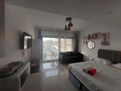 a bedroom with a bed and a living room at Renovated Lovely Cozy Studio in G Cribs, Elgouna in Hurghada