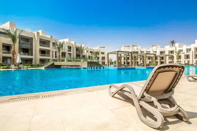 a chair sitting in front of a swimming pool at Ollystays Mangroovy 2 BR Beach and Pool Free access in Hurghada