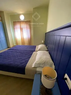 a bedroom with a blue bed with a bucket next to it at FabbricaCasa Sea Front Villa, Oriental Coast in Marsa Alam City