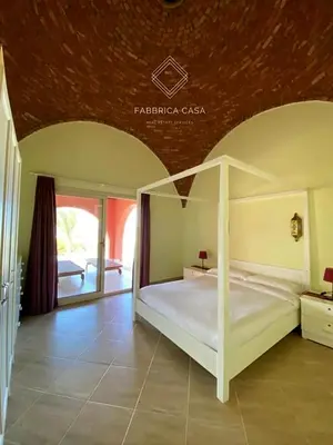 a bedroom with a white bed in a room at FabbricaCasa Sea Front Villa, Oriental Coast in Marsa Alam City