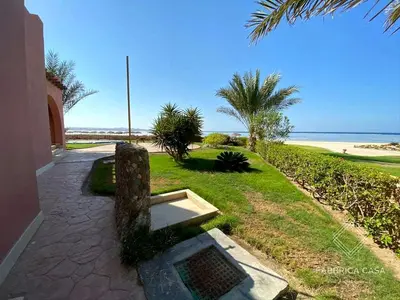 a stone bench sitting on a walkway near the beach at FabbricaCasa Sea Front Villa, Oriental Coast in Marsa Alam City