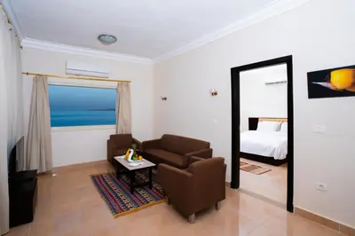 a living room with a chair and a bed and a mirror at New Eagles Aqua Park Resort in Hurghada