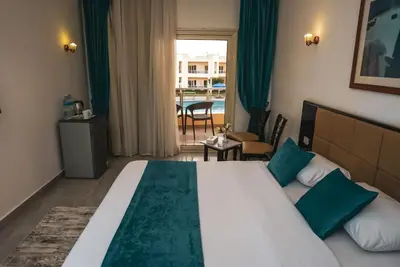 a hotel room with a large bed and a balcony at New Eagles Aqua Park Resort in Hurghada
