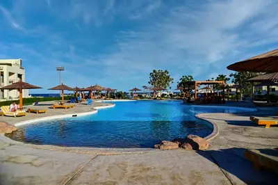 a pool at a resort with chairs and umbrellas at New Eagles Aqua Park Resort in Hurghada