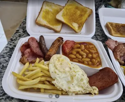 a tray of breakfast food with eggs sausage beans and french toast at Tiba View - Unit no B15 - near ElGouna in Hurghada
