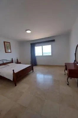 a bedroom with a bed and a desk and a window at Amazing 2 bedrooms' Flat Marina El-Hurghadah in Hurghada
