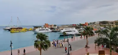 a group of people walking around a marina with boats at Amazing 2 bedrooms' Flat Marina El-Hurghadah in Hurghada