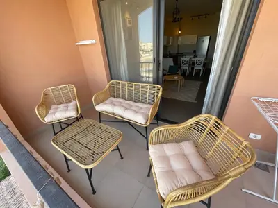 three rattan chairs and chairs on a balcony at Boho Chic - Scenic Lagoon View at Tawila, Gouna in Hurghada