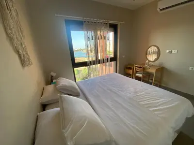 a bedroom with a white bed and a window at Boho Chic - Scenic Lagoon View at Tawila, Gouna in Hurghada