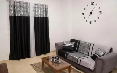 a living room with a couch and a clock on the wall at Turtles Beach Resort - Sea View in Hurghada