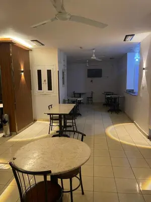 a room with tables and chairs and a tv at Grand Hotel Qena in Qena