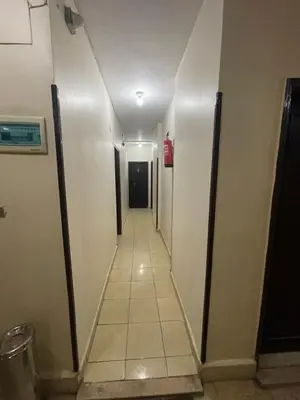 a long hallway with a fire extinguisher in a building at Grand Hotel Qena in Qena