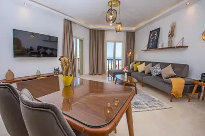a living room with a table and a couch at OSKENA Azzurra Sahl Hasheesh Hurghada in Hurghada