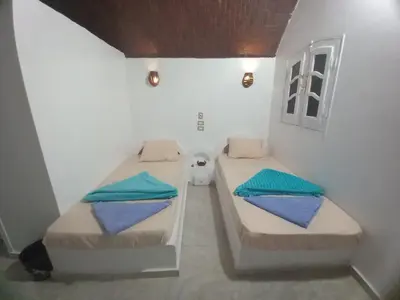 a small room with two beds in it at Kafana Guest House Nile View in Aswan