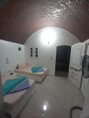 a small room with two beds and a ceiling at Kafana Guest House Nile View in Aswan