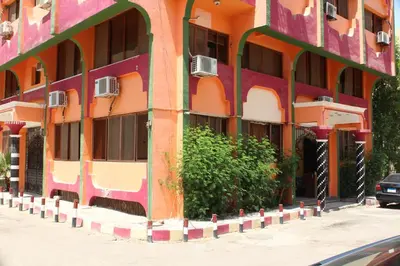 an orange and pink building on the side of a street at Tiba Hotel in Aswan