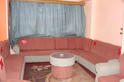 a living room with a red couch and a window at Tiba Hotel in Aswan