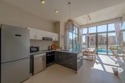 a kitchen with stainless steel appliances and a large window at La Casa de Playa Tawila on Island 4BR Private with Heated Pool in Hurghada